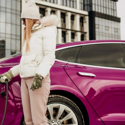 Purple used electric vehicle charged by women
