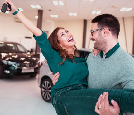 The couple is happy because he is in the process of buying a new car.