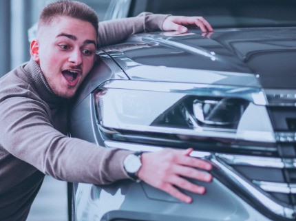 A man is happy because he is in the process of buying a new car