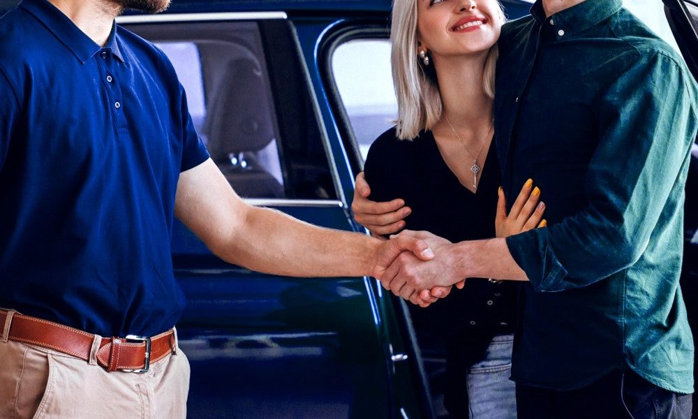 Guys shaking hands because one of them is buying a new car