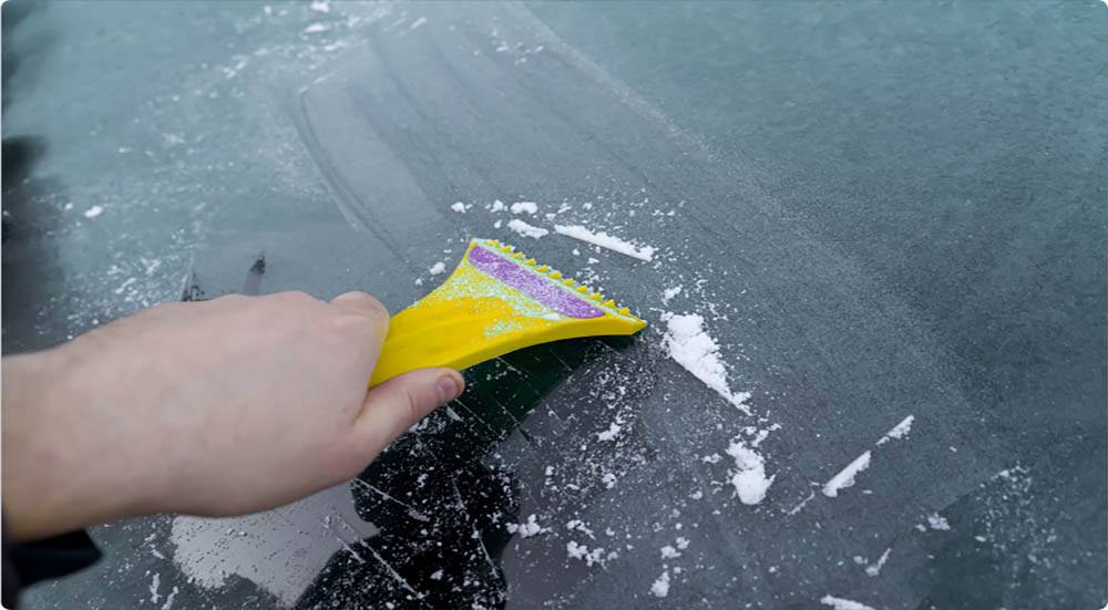 Defrosting car windows with a special scraper tool